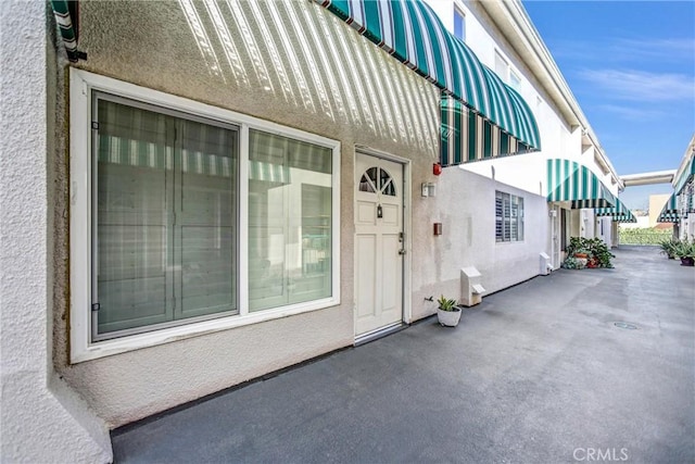 view of exterior entry with stucco siding