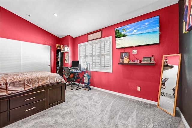 carpeted bedroom with vaulted ceiling and baseboards