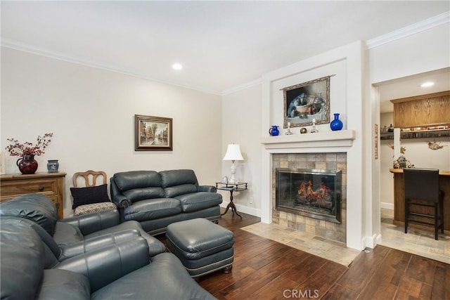 living room with dark wood-style flooring, a fireplace, recessed lighting, ornamental molding, and baseboards