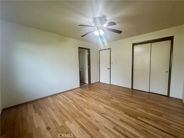 unfurnished bedroom featuring baseboards, light wood-type flooring, a closet, and ceiling fan