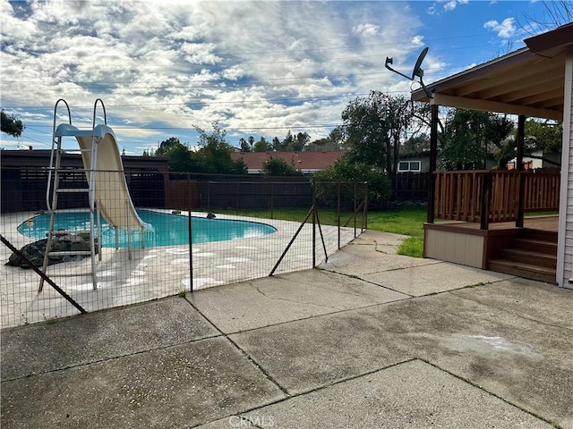 view of swimming pool featuring a fenced backyard, a water slide, a patio, and a fenced in pool