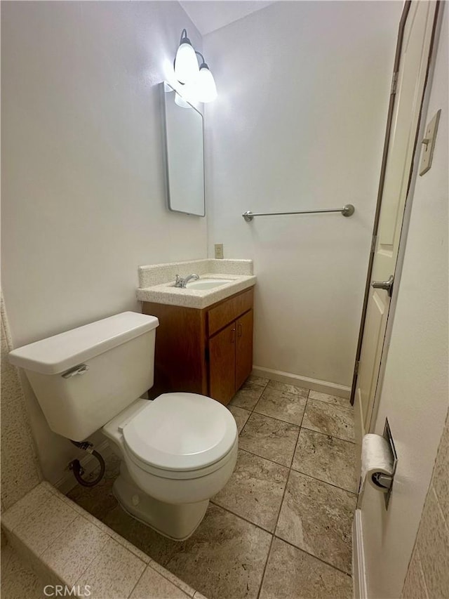 half bath featuring toilet, tile patterned flooring, and vanity