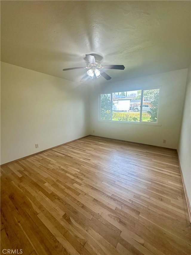spare room featuring wood finished floors, ceiling fan, and a textured ceiling
