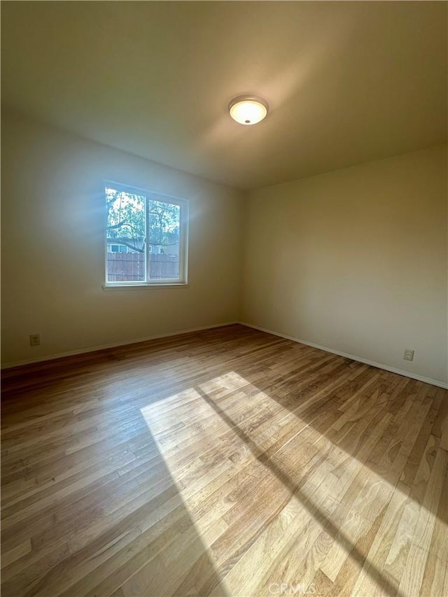 unfurnished room featuring baseboards and wood finished floors