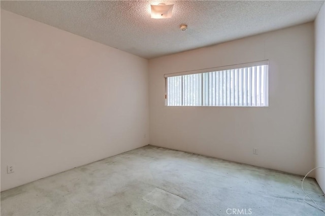 unfurnished room featuring a textured ceiling and carpet flooring