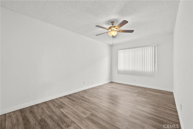 unfurnished room featuring a ceiling fan, a textured ceiling, baseboards, and wood finished floors