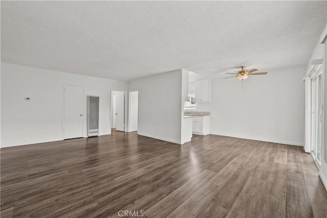 unfurnished living room with a textured ceiling, a ceiling fan, and dark wood-style flooring