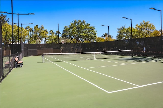 view of tennis court featuring fence