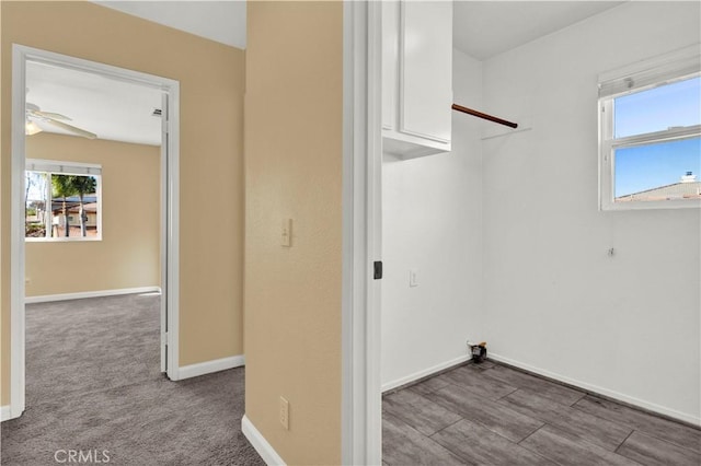 laundry area featuring carpet floors, laundry area, baseboards, and a ceiling fan