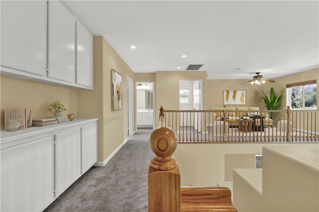 corridor featuring recessed lighting, light colored carpet, visible vents, and baseboards