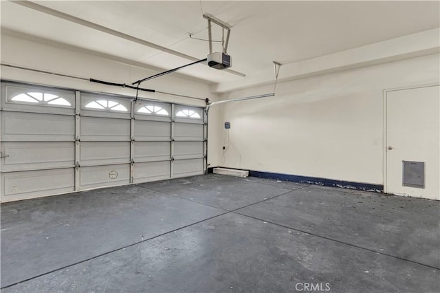 garage with a garage door opener and electric panel