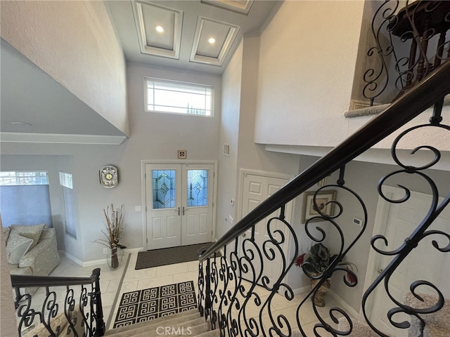 foyer entrance with tile patterned flooring, recessed lighting, a towering ceiling, baseboards, and stairs