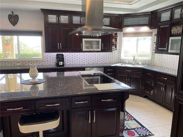 kitchen featuring backsplash, a sink, and island range hood