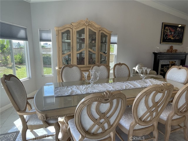 dining area with lofted ceiling, a fireplace, and baseboards