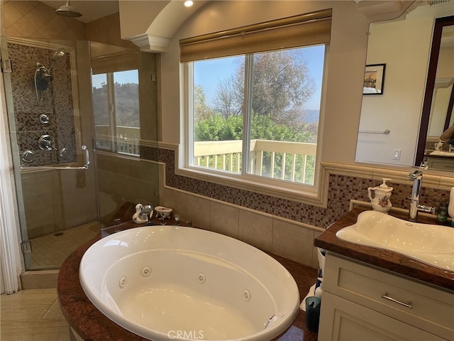 bathroom with a shower stall, a tub with jets, and vanity