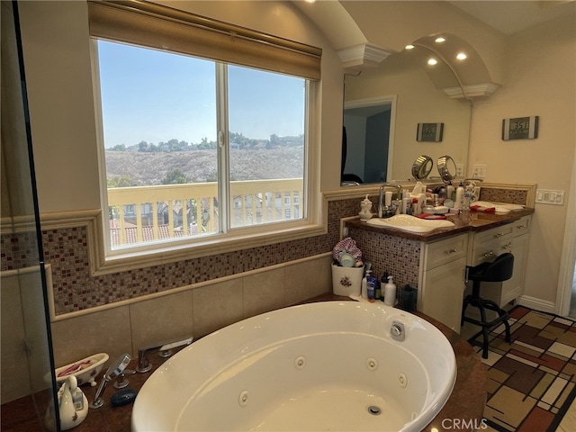 full bathroom with a jetted tub and a sink