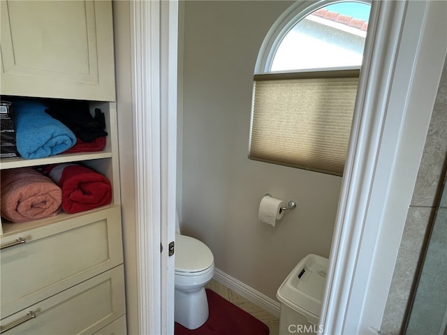 bathroom with toilet and baseboards