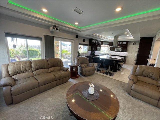 living area featuring light tile patterned floors, a raised ceiling, visible vents, and recessed lighting