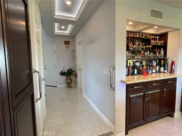 bar with a dry bar, baseboards, visible vents, marble finish floor, and a tray ceiling