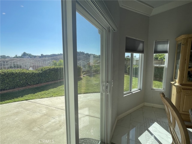 doorway featuring plenty of natural light and baseboards