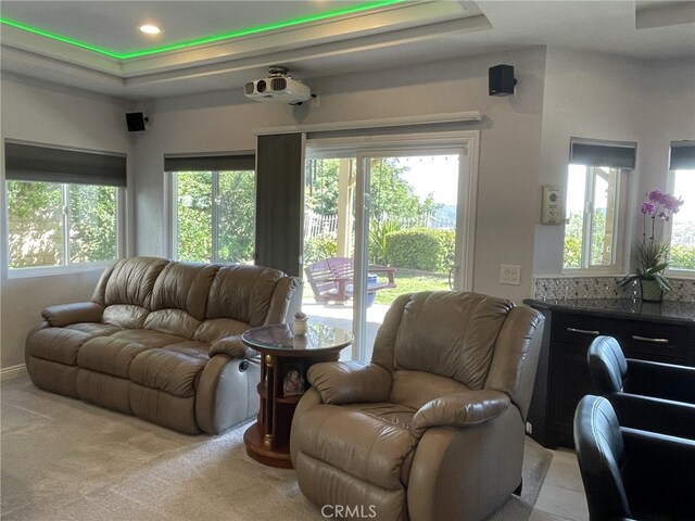 living area with a tray ceiling, light carpet, and recessed lighting