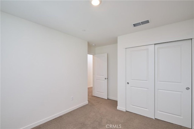 unfurnished bedroom featuring carpet, baseboards, visible vents, and a closet