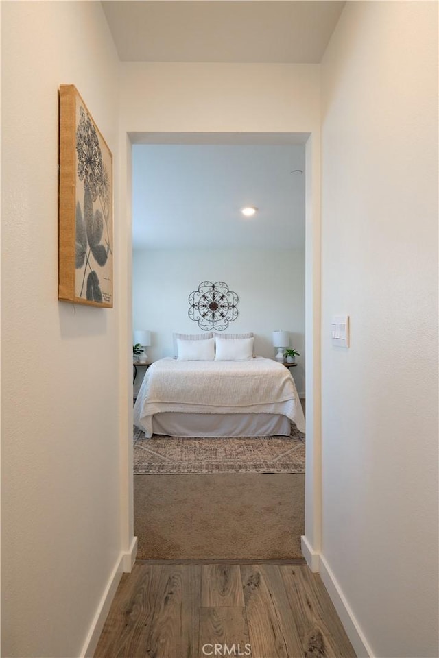 hall featuring wood finished floors and baseboards