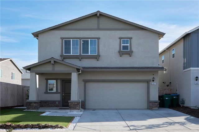 traditional-style home with stone siding, fence, concrete driveway, and stucco siding