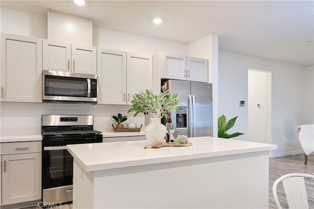 kitchen with a kitchen island, stainless steel appliances, light countertops, light wood-style floors, and recessed lighting