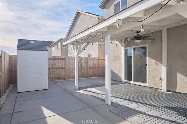 view of patio / terrace featuring an outbuilding, a fenced backyard, ceiling fan, and a shed