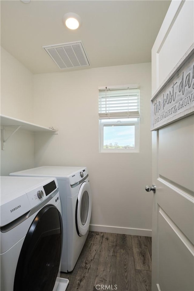 clothes washing area with dark wood-style flooring, visible vents, laundry area, independent washer and dryer, and baseboards