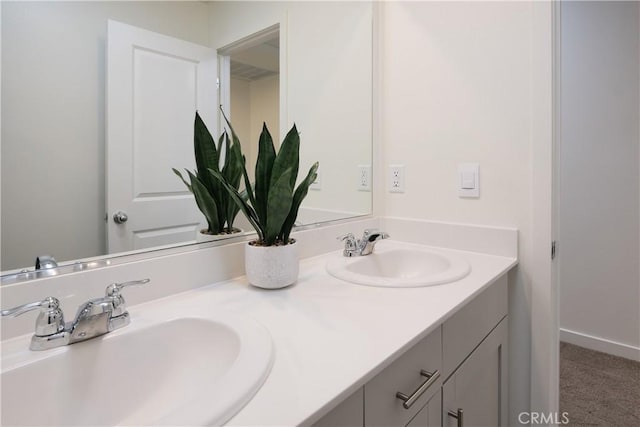 full bath with a sink, baseboards, and double vanity