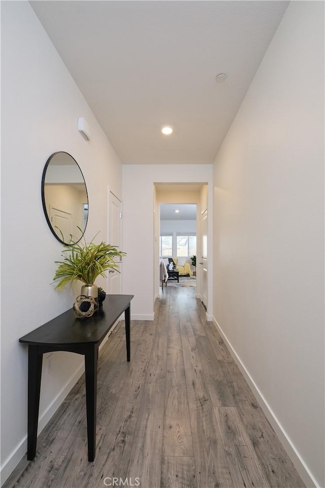 corridor featuring recessed lighting, baseboards, and wood finished floors