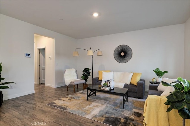 living area with baseboards and wood finished floors