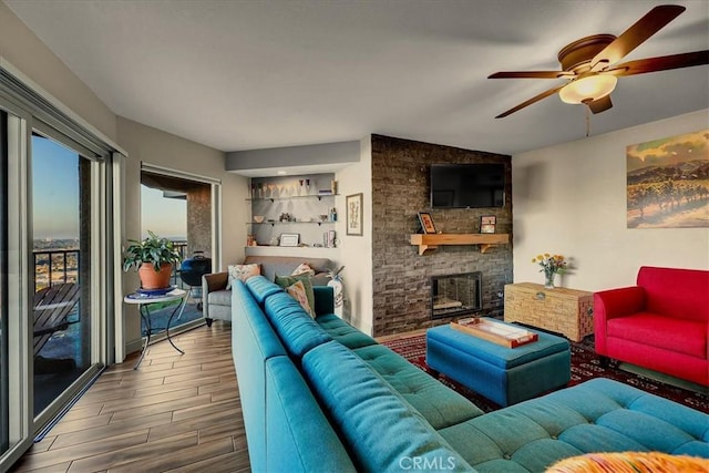 living area with ceiling fan, lofted ceiling, a fireplace, and wood finished floors