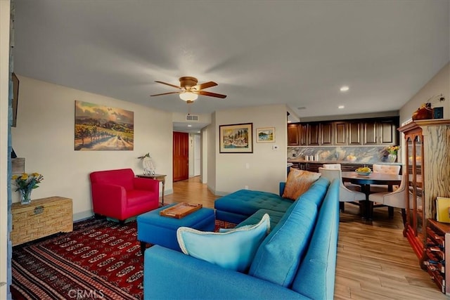 living area with ceiling fan, recessed lighting, visible vents, baseboards, and light wood-style floors