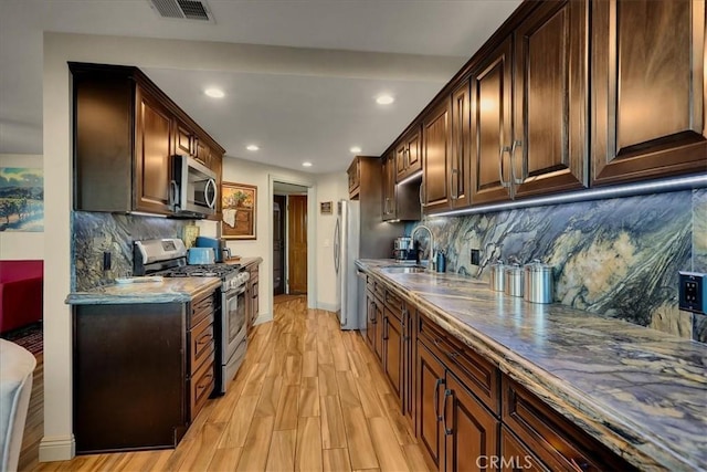 kitchen featuring recessed lighting, stainless steel appliances, visible vents, dark brown cabinets, and light wood finished floors