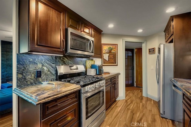 kitchen with recessed lighting, stainless steel appliances, baseboards, light wood-style floors, and tasteful backsplash