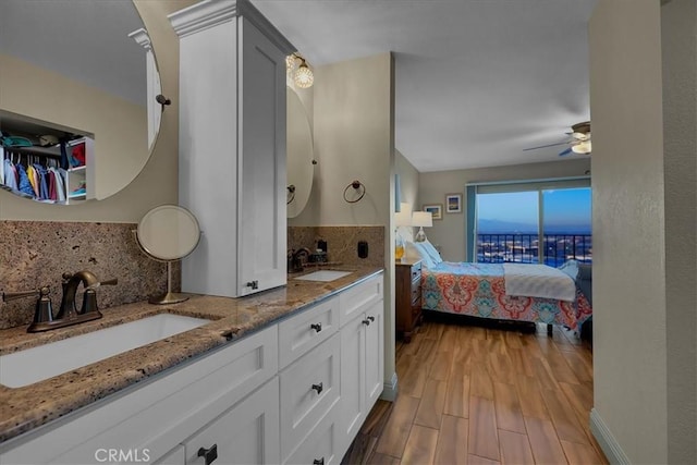 bathroom with decorative backsplash, a sink, ensuite bath, and wood finished floors