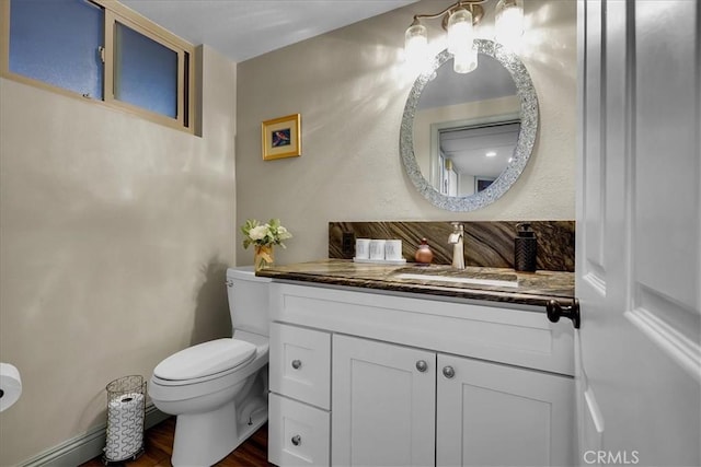 bathroom featuring vanity, toilet, and wood finished floors