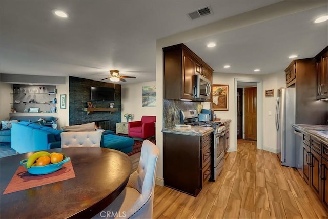 kitchen with light wood finished floors, visible vents, appliances with stainless steel finishes, and dark brown cabinets