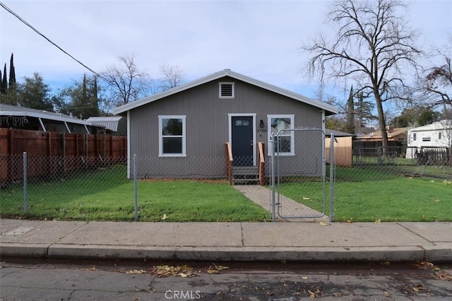 bungalow-style house with a fenced front yard, a gate, and a front lawn