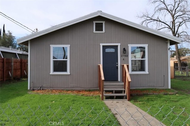 bungalow featuring fence and a front lawn