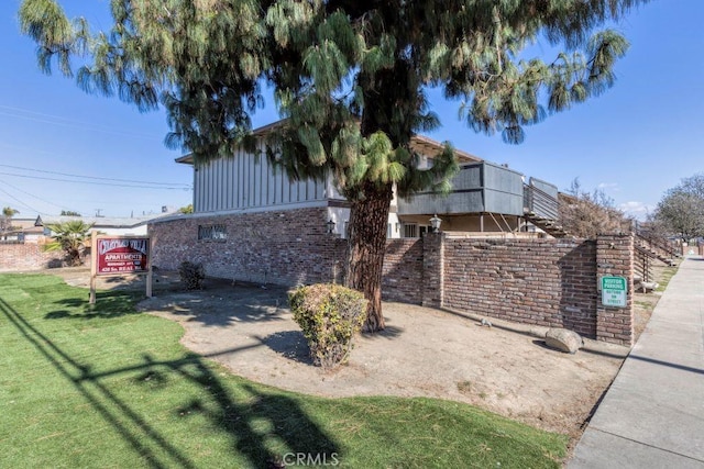 view of property exterior with a yard and brick siding