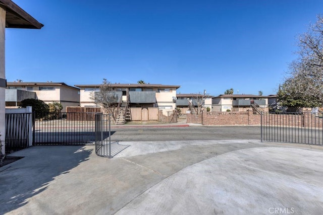 exterior space with a residential view, fence, and stairs