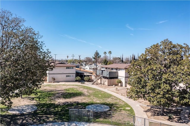 view of yard featuring stairway, fence, and a residential view