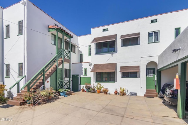 view of front of property with entry steps, stairs, and stucco siding