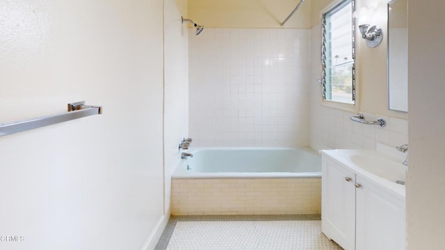 full bathroom featuring tile patterned flooring, tiled shower / bath, and vanity