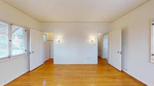 unfurnished room with baseboards and light wood-style floors