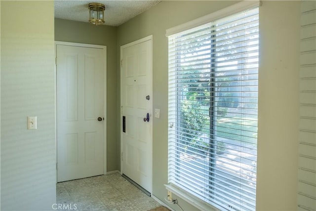 interior space featuring light floors and a textured ceiling